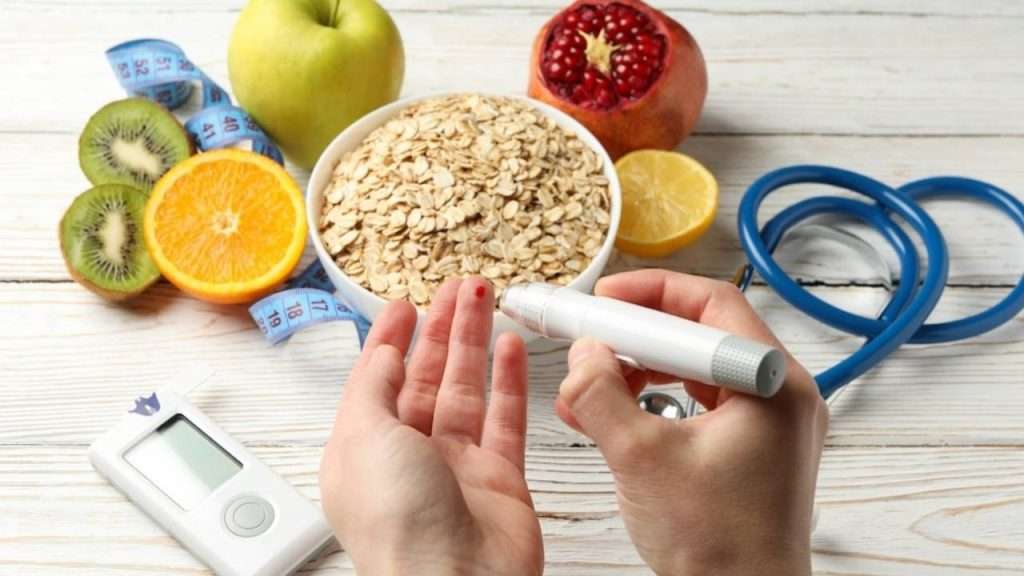 Person checking blood sugar with a glucose device alongside healthy foods and diabetes care essentials.